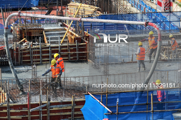 Workers are working outdoors at a commercial housing construction site in Nanjing, China, on June 14, 2024, when the temperature is exceedin...