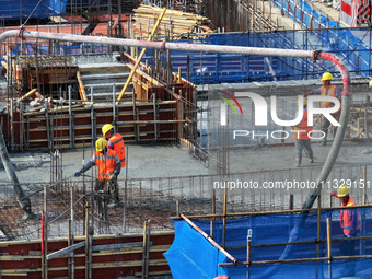 Workers are working outdoors at a commercial housing construction site in Nanjing, China, on June 14, 2024, when the temperature is exceedin...