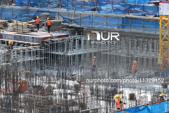 Workers are working outdoors at a commercial housing construction site in Nanjing, China, on June 14, 2024, when the temperature is exceedin...