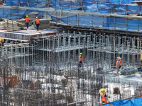 Workers are working outdoors at a commercial housing construction site in Nanjing, China, on June 14, 2024, when the temperature is exceedin...