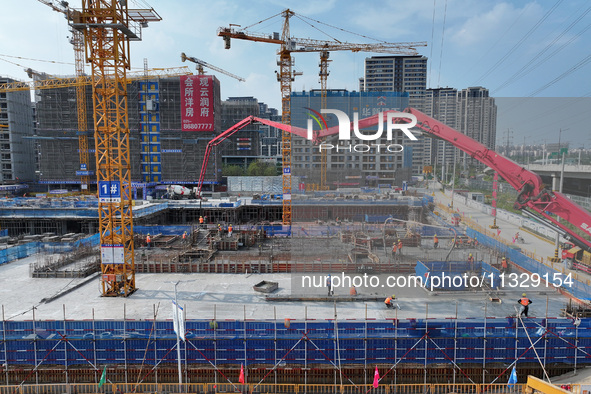 Workers are working outdoors at a commercial housing construction site in Nanjing, China, on June 14, 2024, when the temperature is exceedin...