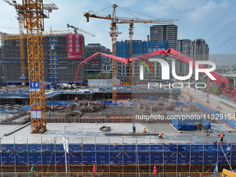 Workers are working outdoors at a commercial housing construction site in Nanjing, China, on June 14, 2024, when the temperature is exceedin...