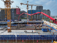 Workers are working outdoors at a commercial housing construction site in Nanjing, China, on June 14, 2024, when the temperature is exceedin...