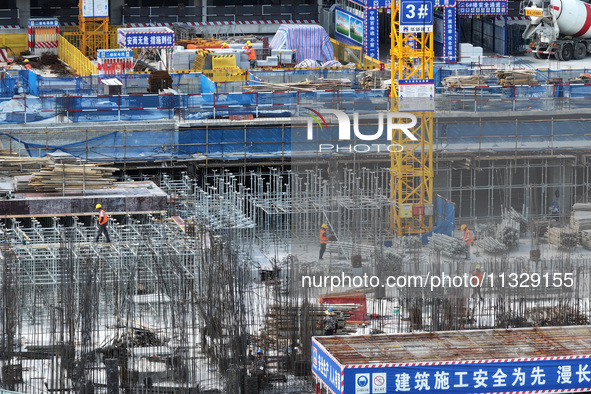 Workers are working outdoors at a commercial housing construction site in Nanjing, China, on June 14, 2024, when the temperature is exceedin...