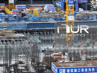 Workers are working outdoors at a commercial housing construction site in Nanjing, China, on June 14, 2024, when the temperature is exceedin...