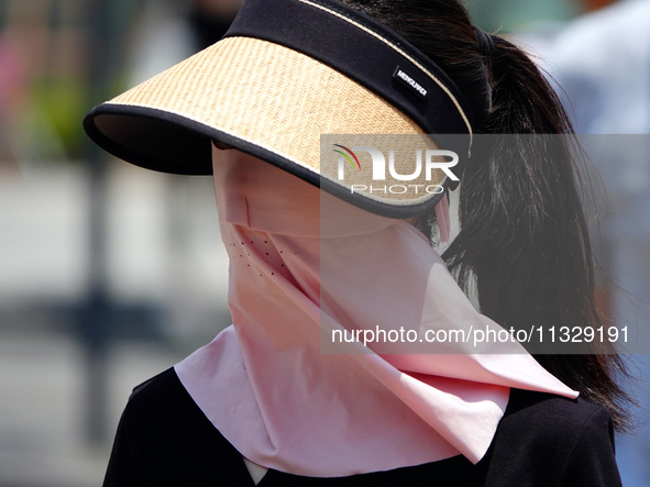 Citizens are wearing sun protection clothes to travel in Yichang, China, on June 14, 2024. 