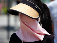 Citizens are wearing sun protection clothes to travel in Yichang, China, on June 14, 2024. (