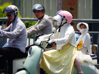 Citizens are wearing sun protection clothes to travel in Yichang, China, on June 14, 2024. (