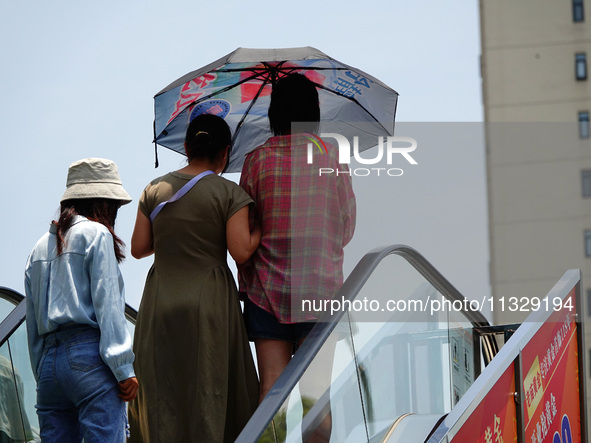 Citizens are wearing sun protection clothes to travel in Yichang, China, on June 14, 2024. 