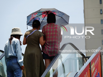 Citizens are wearing sun protection clothes to travel in Yichang, China, on June 14, 2024. (