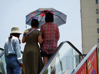 Citizens are wearing sun protection clothes to travel in Yichang, China, on June 14, 2024. (