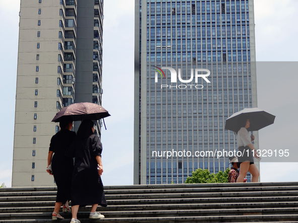 Citizens are wearing sun protection clothes to travel in Yichang, China, on June 14, 2024. 