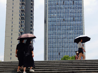 Citizens are wearing sun protection clothes to travel in Yichang, China, on June 14, 2024. (