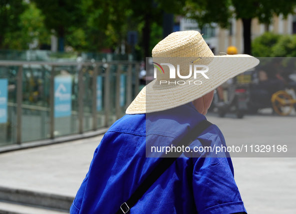 Citizens are wearing sun protection clothes to travel in Yichang, China, on June 14, 2024. 