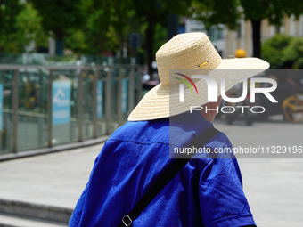 Citizens are wearing sun protection clothes to travel in Yichang, China, on June 14, 2024. (