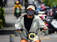 Citizens are wearing sun protection clothes to travel in Yichang, China, on June 14, 2024. (