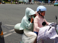 Citizens are wearing sun protection clothes to travel in Yichang, China, on June 14, 2024. (