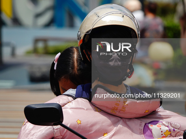 Citizens are wearing sun protection clothes to travel in Yichang, China, on June 14, 2024. 