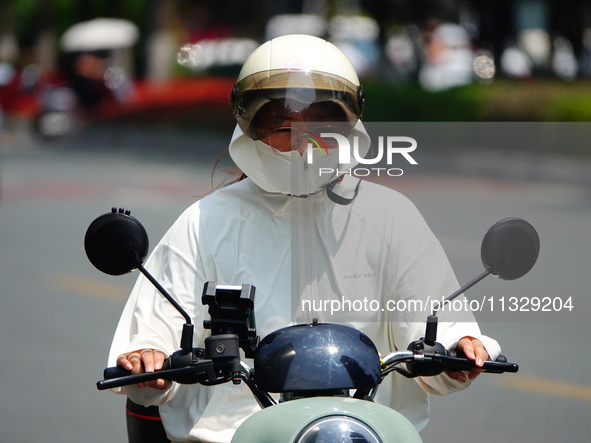 Citizens are wearing sun protection clothes to travel in Yichang, China, on June 14, 2024. 