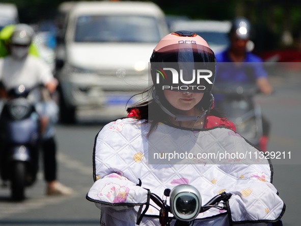 Citizens are wearing sun protection clothes to travel in Yichang, China, on June 14, 2024. 