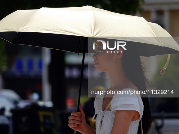 Citizens are wearing sun protection clothes to travel in Yichang, China, on June 14, 2024. 