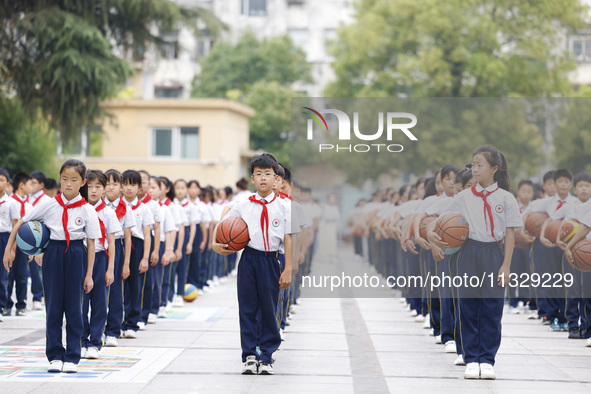 Primary school students are demonstrating basketball exercises at a school in Suqian, Jiangsu province, China, on June 14, 2024. 