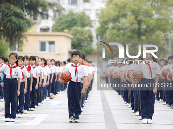 Primary school students are demonstrating basketball exercises at a school in Suqian, Jiangsu province, China, on June 14, 2024. (