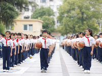 Primary school students are demonstrating basketball exercises at a school in Suqian, Jiangsu province, China, on June 14, 2024. (