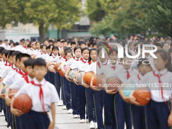 Primary school students are demonstrating basketball exercises at a school in Suqian, Jiangsu province, China, on June 14, 2024. (