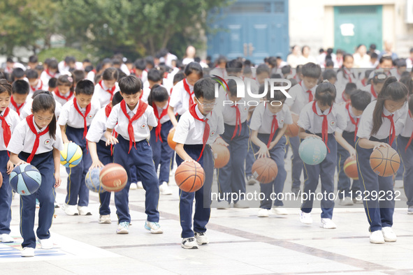 Primary school students are demonstrating basketball exercises at a school in Suqian, Jiangsu province, China, on June 14, 2024. 