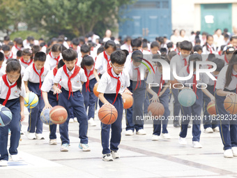 Primary school students are demonstrating basketball exercises at a school in Suqian, Jiangsu province, China, on June 14, 2024. (