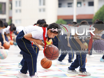 Primary school students are demonstrating basketball exercises at a school in Suqian, Jiangsu province, China, on June 14, 2024. (