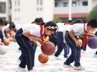 Primary school students are demonstrating basketball exercises at a school in Suqian, Jiangsu province, China, on June 14, 2024. (