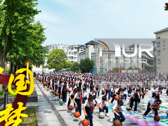 Primary school students are demonstrating basketball exercises at a school in Suqian, Jiangsu province, China, on June 14, 2024. (