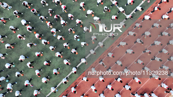 Primary school students are demonstrating basketball exercises at a school in Suqian, Jiangsu province, China, on June 14, 2024. 