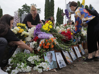 Women are laying flowers at the grave of Ukrainian serviceman, artist, musician, stylist, and queer community member Artur Snitkus, 36, who...