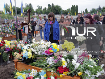 People are laying flowers at the grave of Ukrainian serviceman, artist, musician, stylist, and queer community member Artur Snitkus, 36, who...