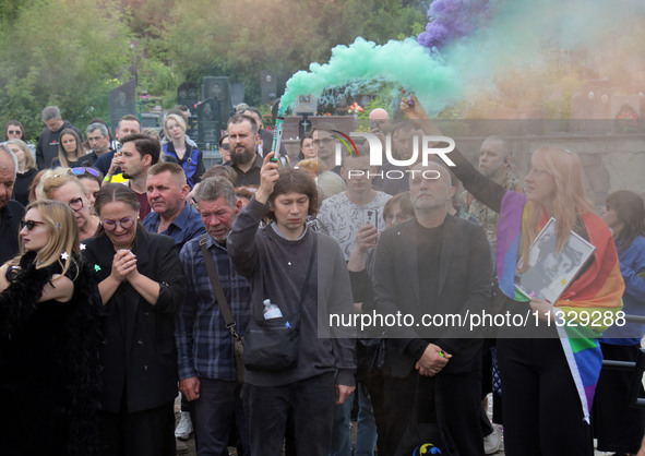 Mourners are holding smoke bombs during the funeral of Ukrainian serviceman, artist, musician, stylist, and queer community member Artur Sni...