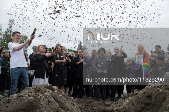 People are launching confetti from party poppers during the funeral of Ukrainian serviceman, artist, musician, stylist, and queer community...