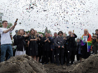 People are launching confetti from party poppers during the funeral of Ukrainian serviceman, artist, musician, stylist, and queer community...