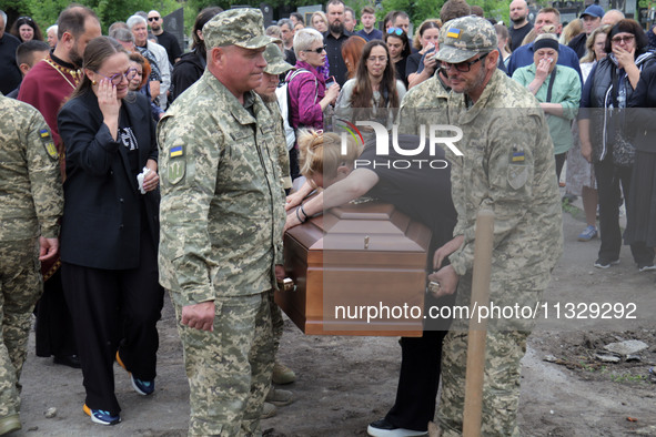 A woman is mourning by the coffin of Ukrainian serviceman, artist, musician, stylist, and queer community member Artur Snitkus, 36, who peri...