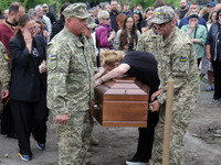 A woman is mourning by the coffin of Ukrainian serviceman, artist, musician, stylist, and queer community member Artur Snitkus, 36, who peri...