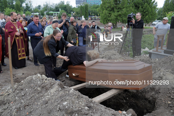 A woman is mourning by the coffin of Ukrainian serviceman, artist, musician, stylist, and queer community member Artur Snitkus, 36, who peri...