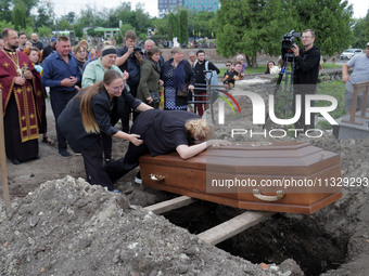 A woman is mourning by the coffin of Ukrainian serviceman, artist, musician, stylist, and queer community member Artur Snitkus, 36, who peri...