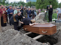 A woman is mourning by the coffin of Ukrainian serviceman, artist, musician, stylist, and queer community member Artur Snitkus, 36, who peri...