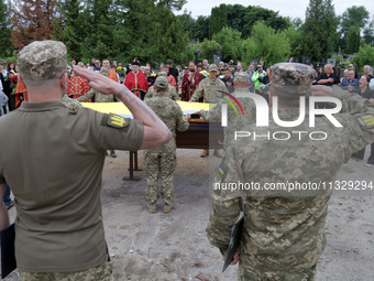 Soldiers are saluting at the coffin of Ukrainian serviceman, artist, musician, stylist, and queer community member Artur Snitkus, 36, who pe...