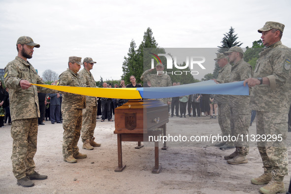 Soldiers are covering the coffin of Ukrainian serviceman, artist, musician, stylist, and queer community member Artur Snitkus, 36, who peris...