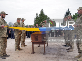 Soldiers are covering the coffin of Ukrainian serviceman, artist, musician, stylist, and queer community member Artur Snitkus, 36, who peris...