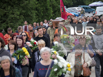 Soldiers are carrying the coffin of Ukrainian serviceman, artist, musician, stylist, and queer community member Artur Snitkus, 36, who peris...