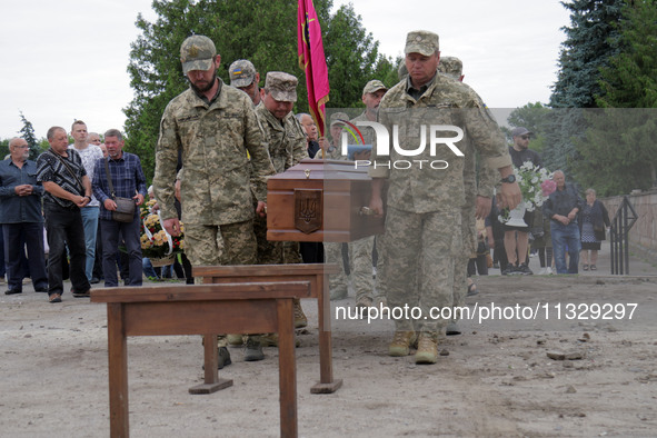 Soldiers are carrying the coffin of Ukrainian serviceman, artist, musician, stylist, and queer community member Artur Snitkus, 36, who peris...